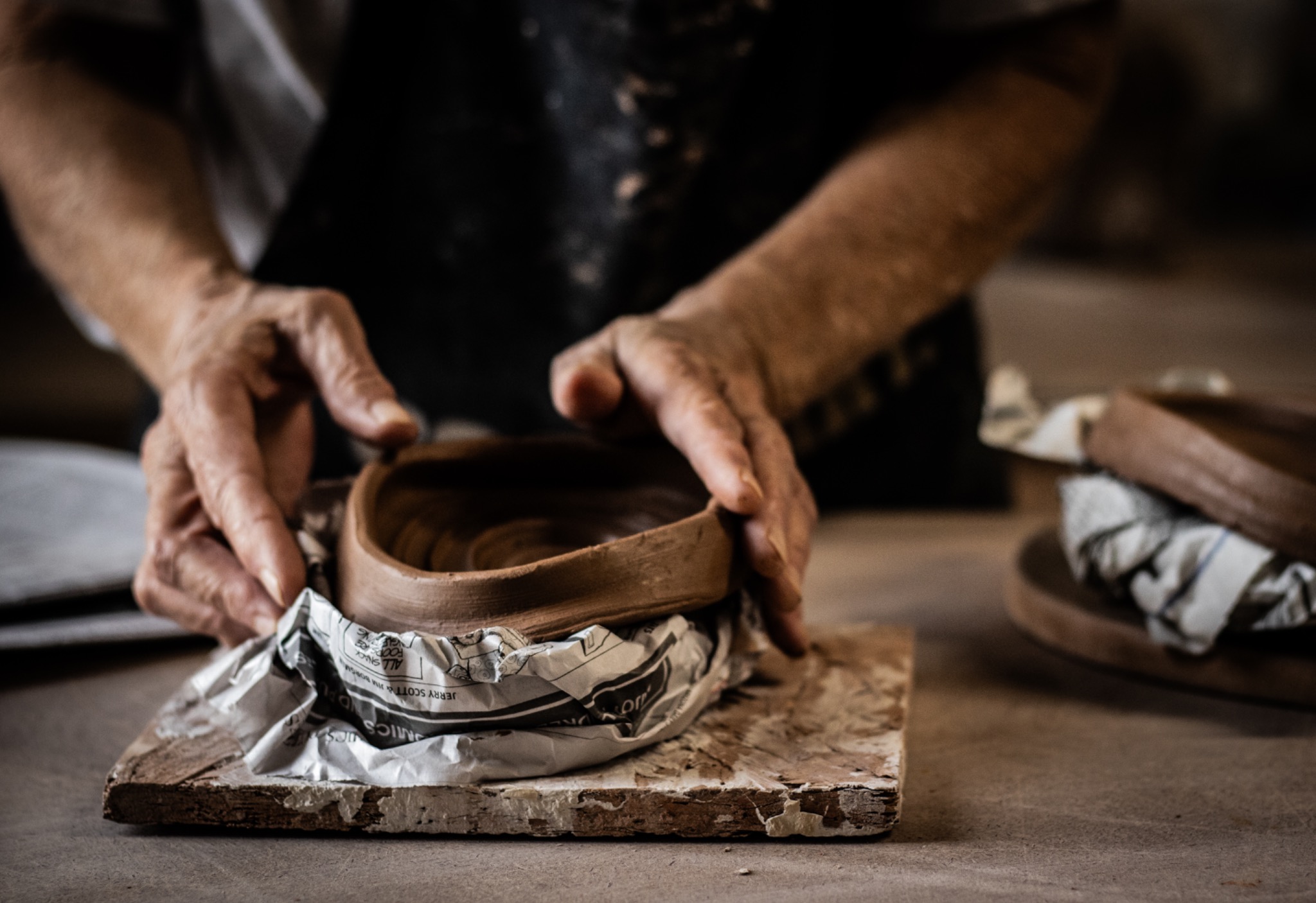 A ceramic artist’s hands shaping a newly made clay bowl